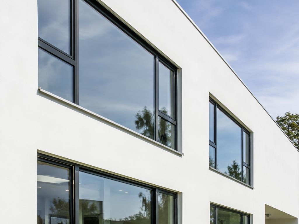 Imagen referencial de ventanas de aluminio en fachada blanca